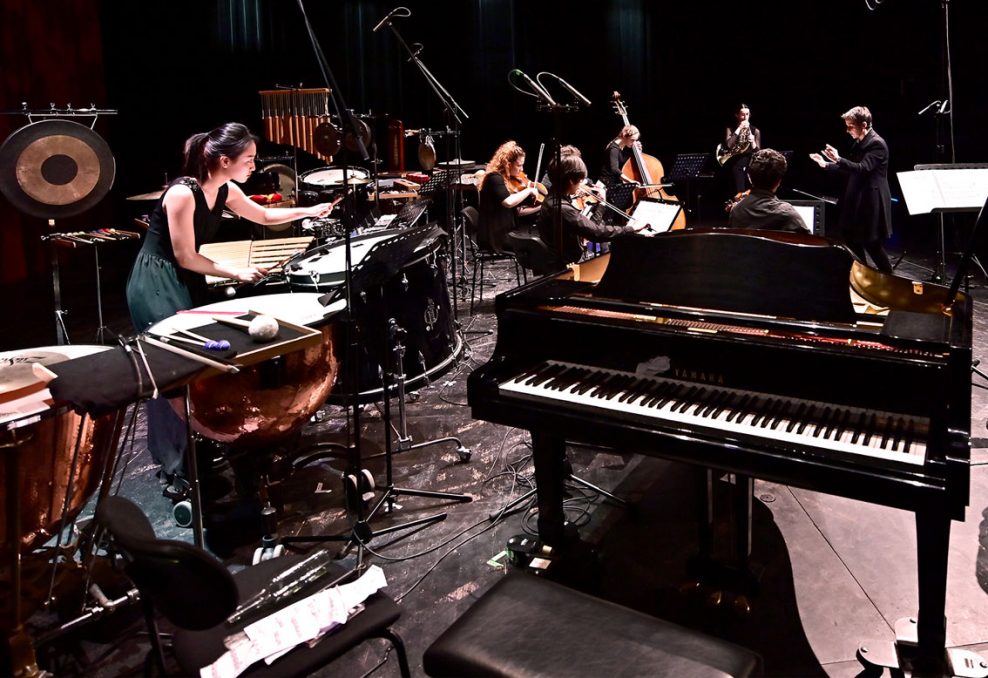 Ein Ensemble junger Musikerinnen und Musiker mit verschiedenen Instrumenten während einer Aufführung.