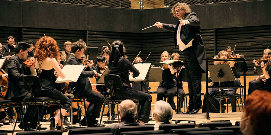 Foto von einem Orchester auf der Bühne mit dem Dirigenten Marcus Bosch
